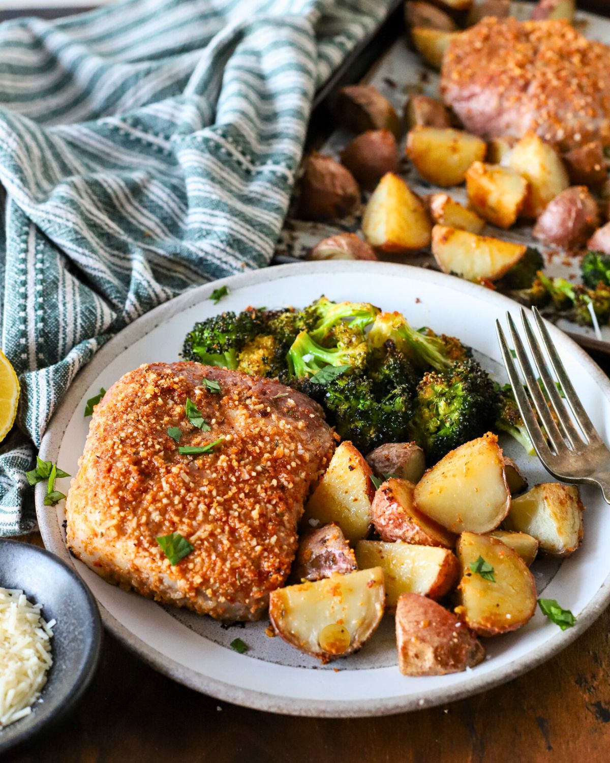 Plate with baked pork chops, potatoes, and broccoli.