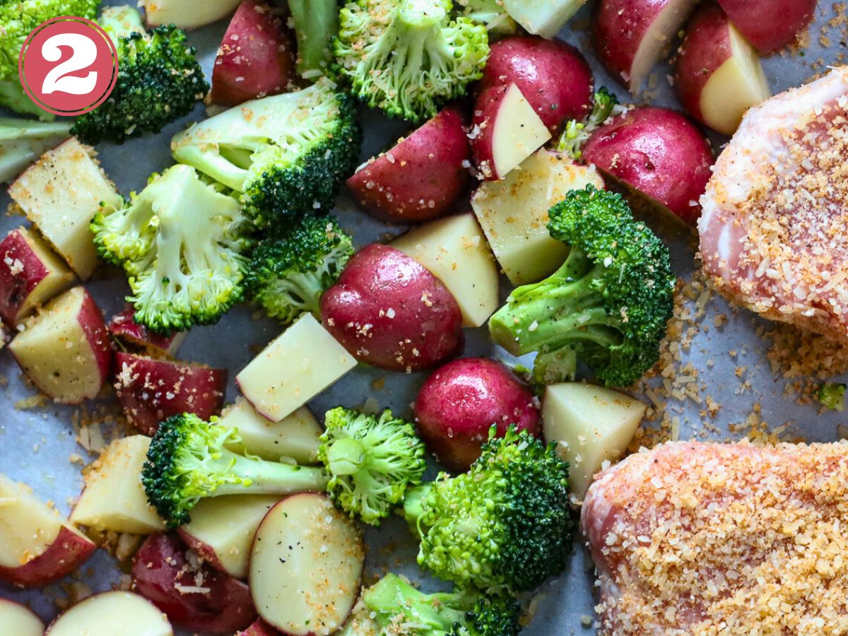 A sheet pan full of cut potatoes and broccoli.