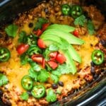 Mexican casserole with ground beef topped with avocado in a crock pot.