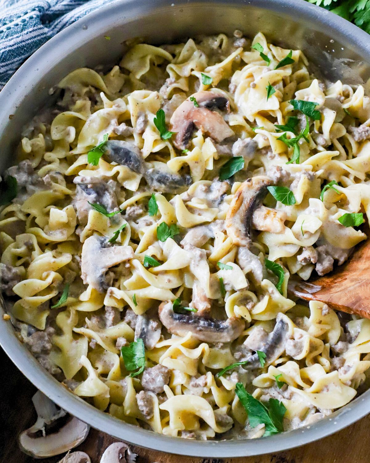 Pot full of ground beef stroganoff topped with chopped parsley.