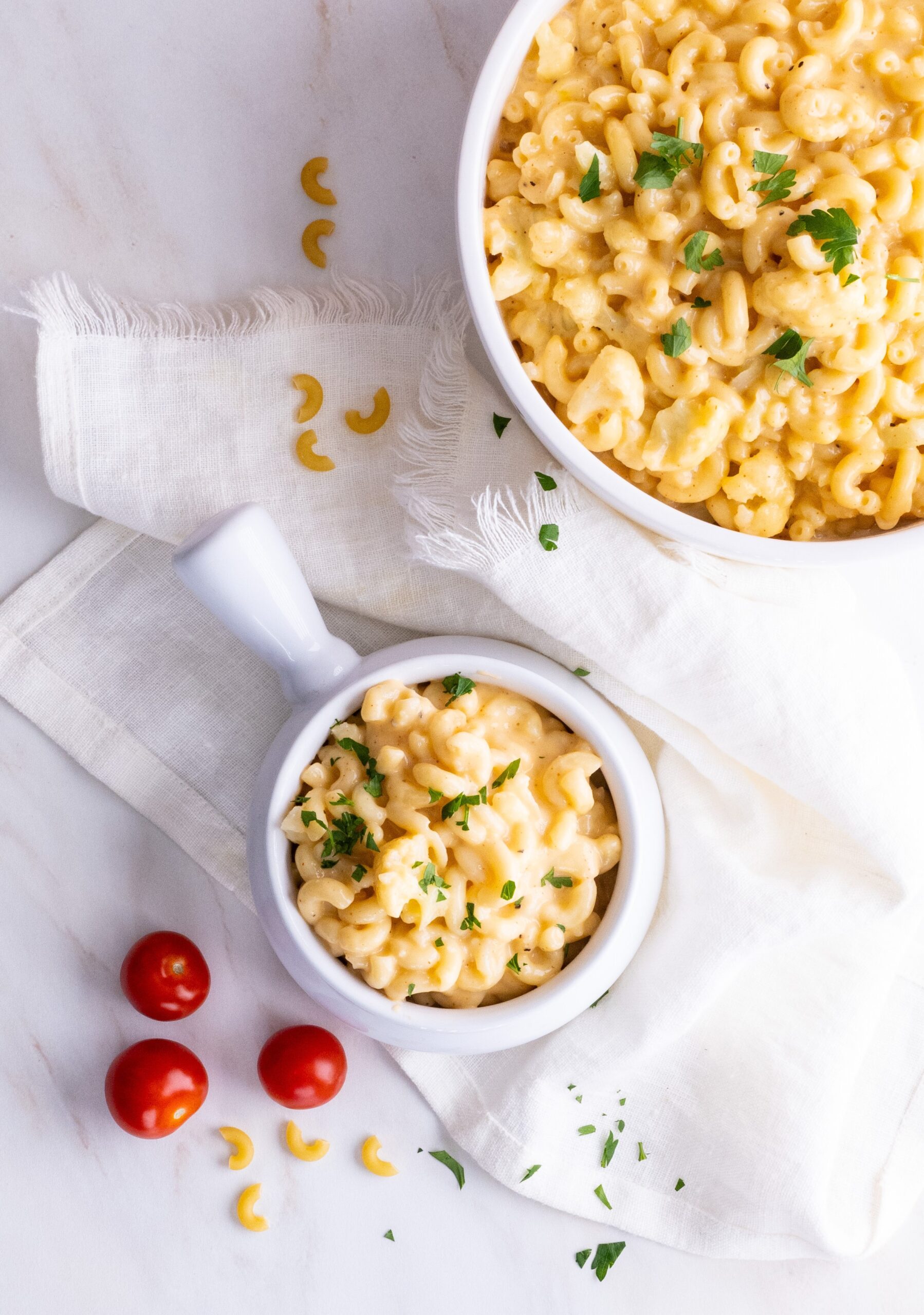 Pot of cauliflower mac and cheese topped with fresh parsely.