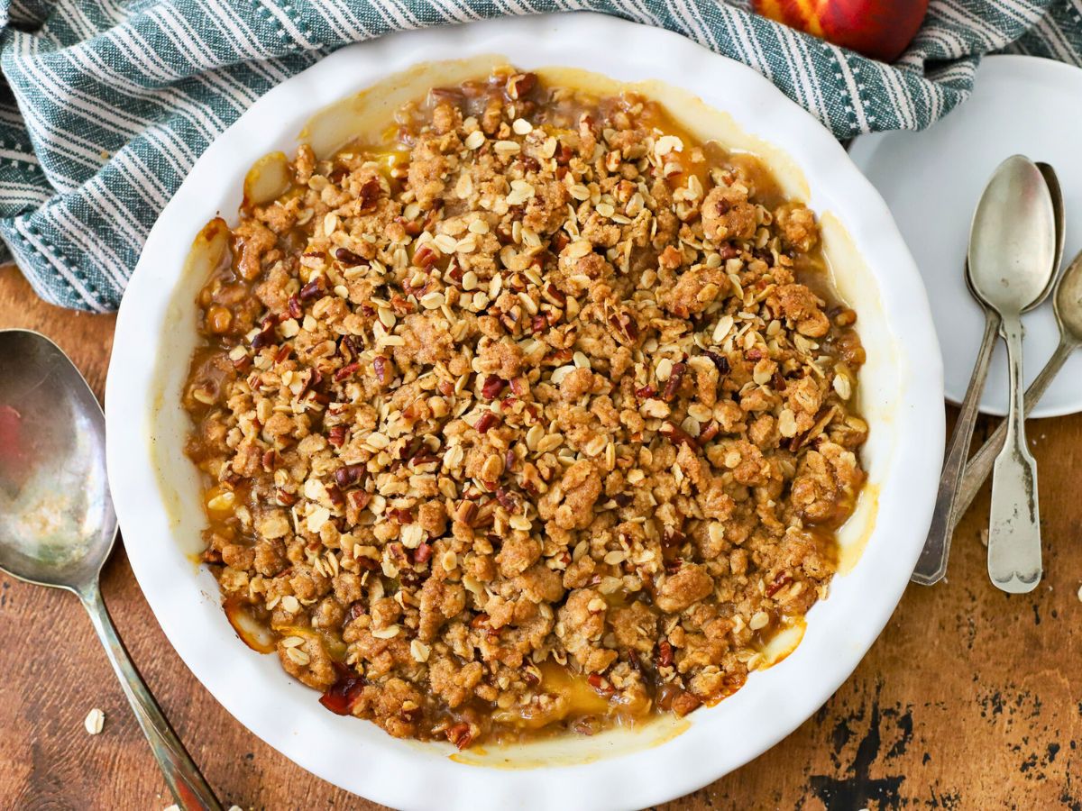 Pie dish filled with peach crisp made with canned peaches.