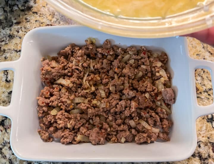 Pouring egg and hashbrown mixture over sausage