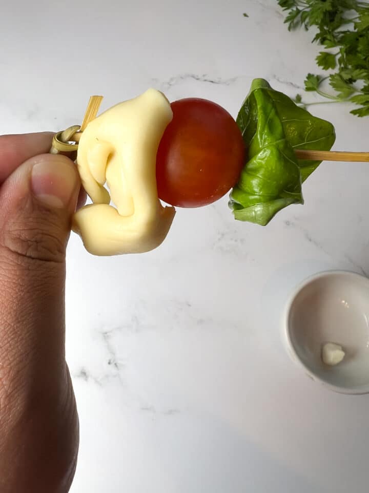 tortellini caprese skewers being assembled