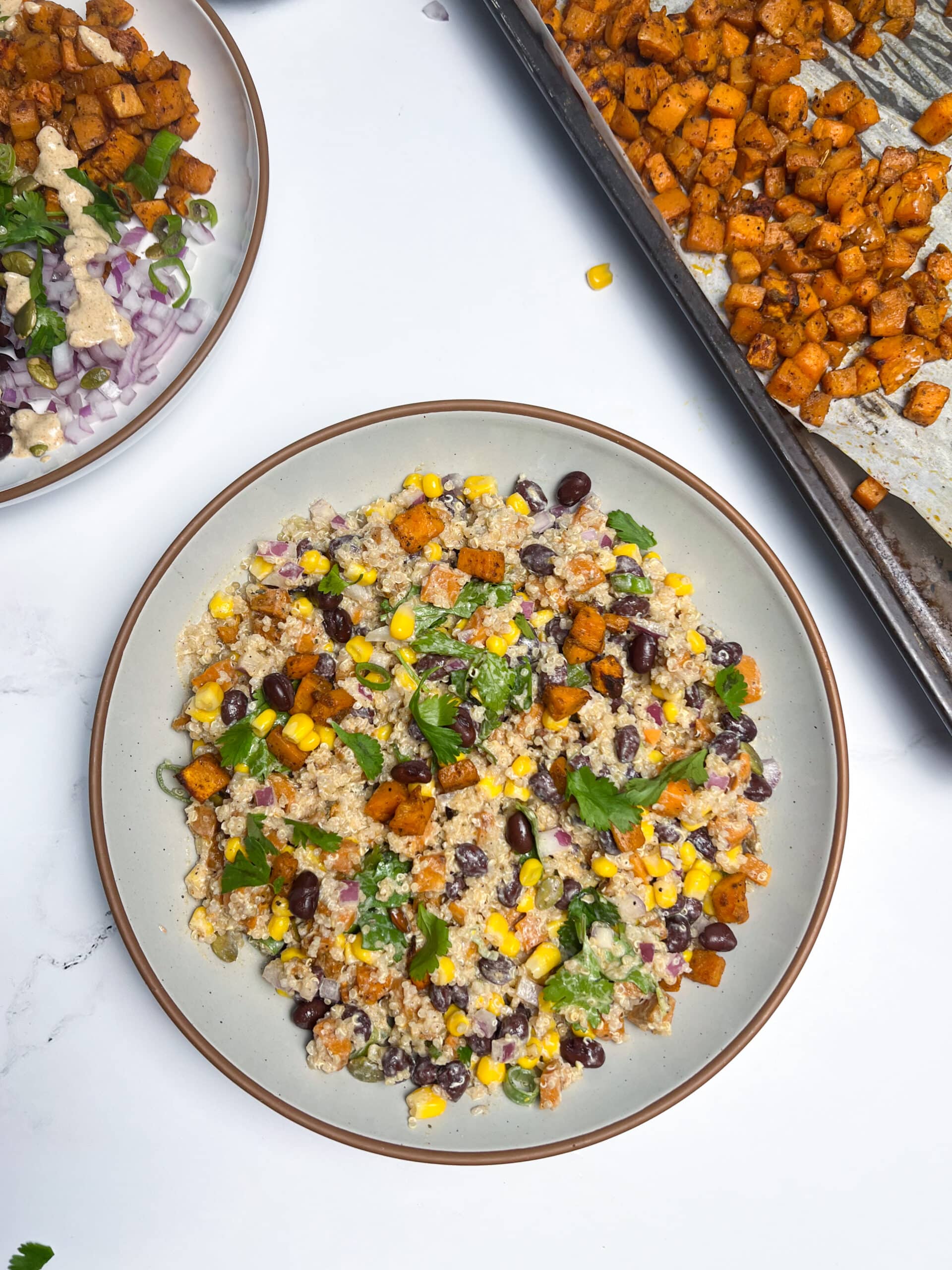 Roasted Sweet Potato and Black Bean Quinoa Bowls mixed together with dressing