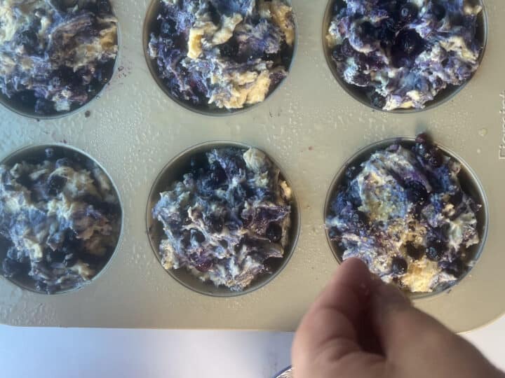 Sprinkling turbinado sugar on unbaked muffins