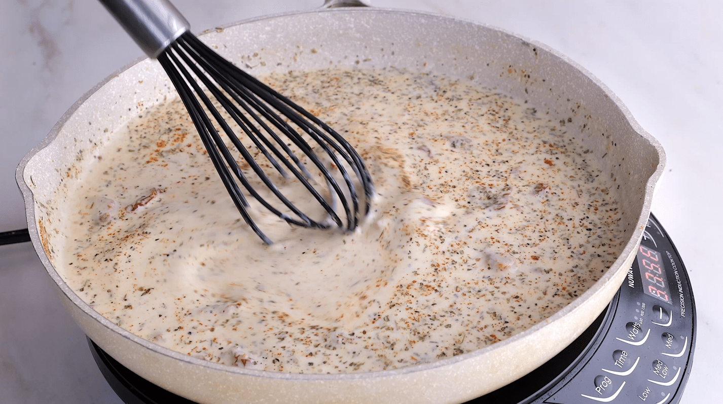 Creamy marry me chicken sauce being whisked in a skillet