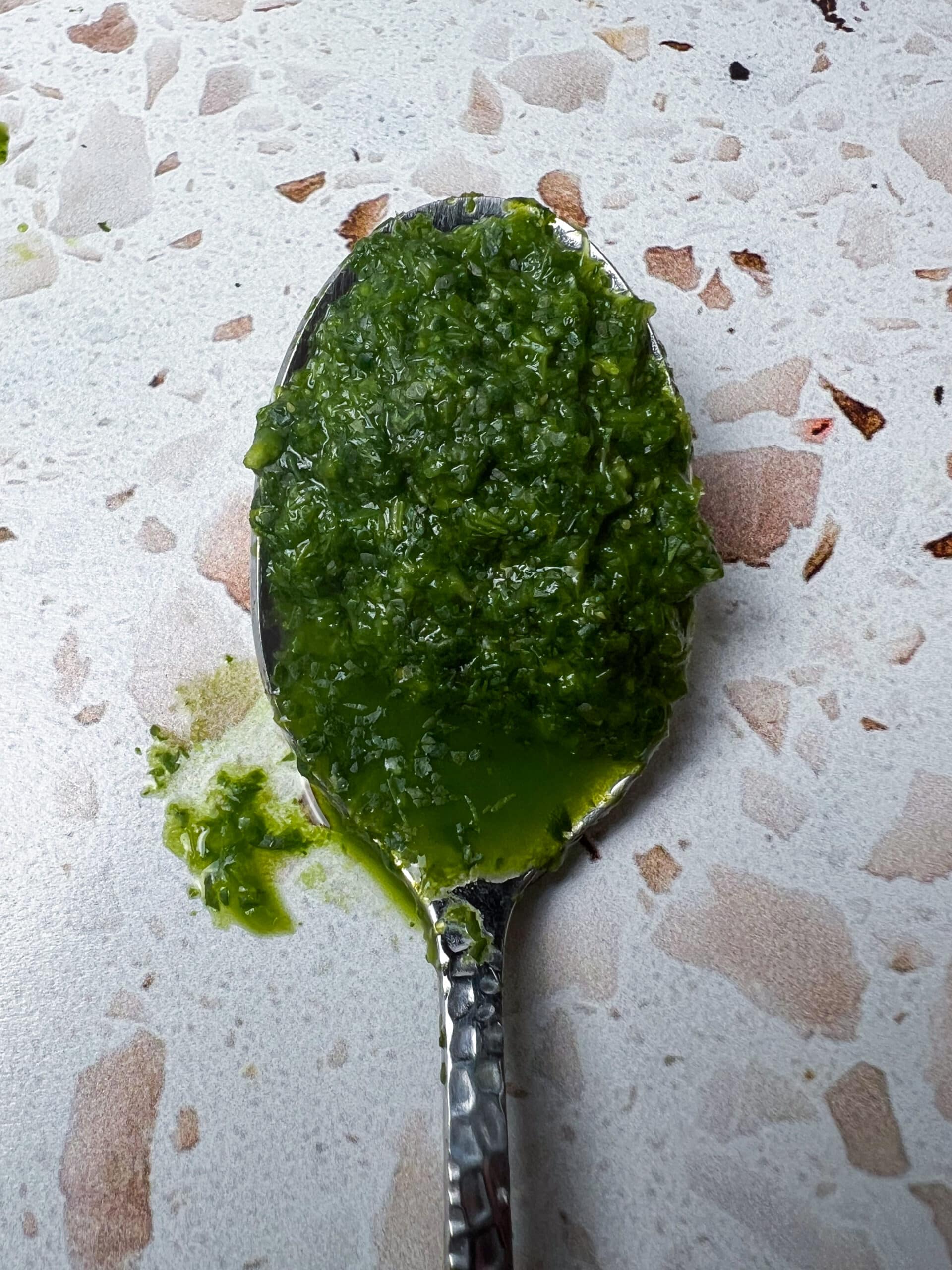 Close-up of green chutney on a spoon to show texture