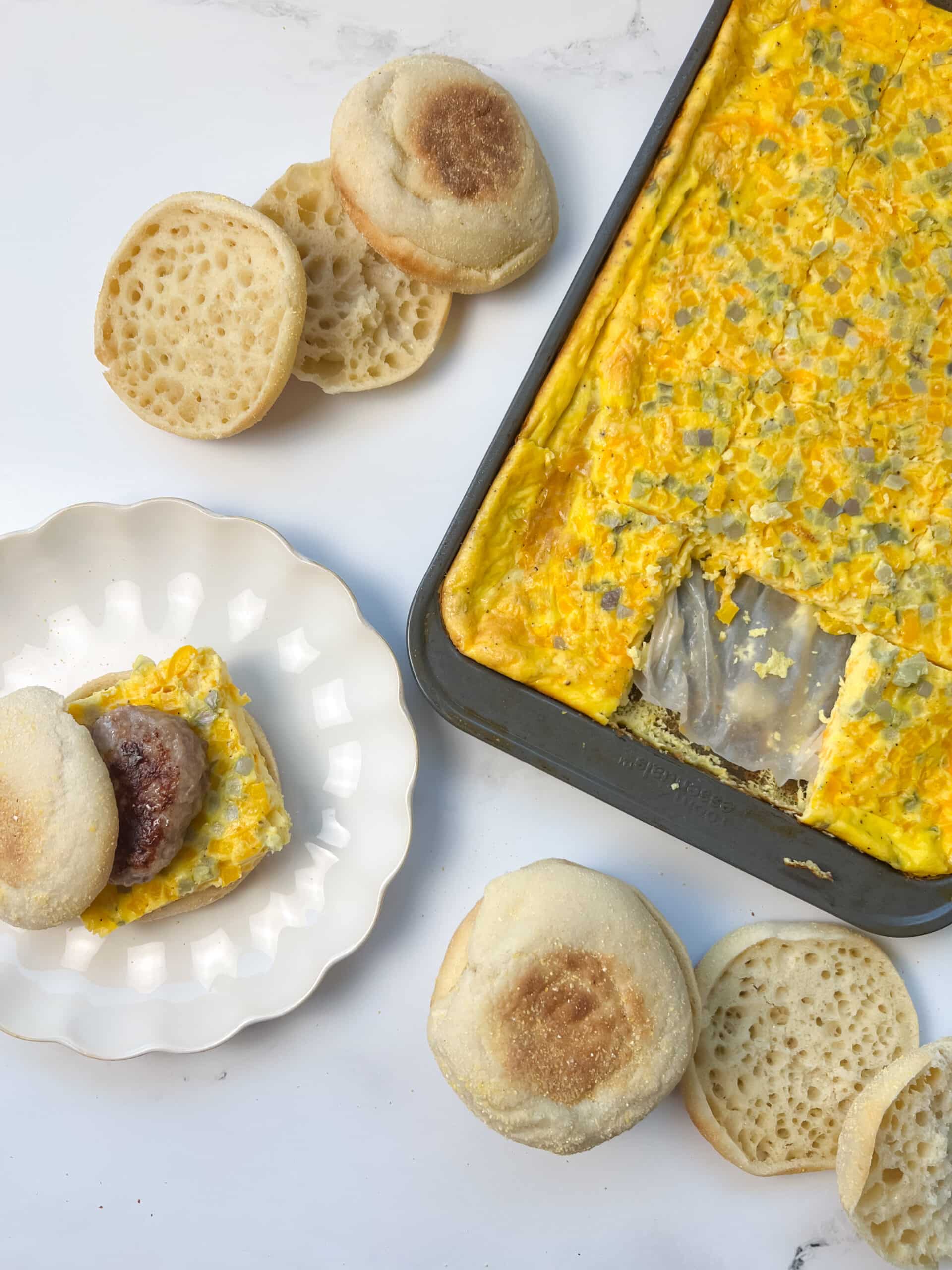 Sheet pan eggs with a slice on a breakfast sandwich